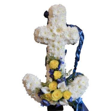 Begravningsblomma som utformar ett vitt ankare med vita och blå detaljer. Gula och vita blommor är längst ner i mitten på ankaret, och ett blått band hänger ner bakifrån ankaret.Ankaret är ett personligt arrangemang.
