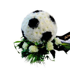 Begravningsblomma i form av en svart vit klassisk fotboll.Fotbollen ligger på gröna blad och vita blommor och är ett personligt arrangemang.