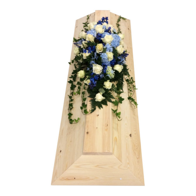 Begravningsblommor som används som kistdekoration på begravningskista gjord av träd. Blommorna är vita rosor,blå hortensia,delfinium och lite murgröna. Blommorna ger en havskänsla.